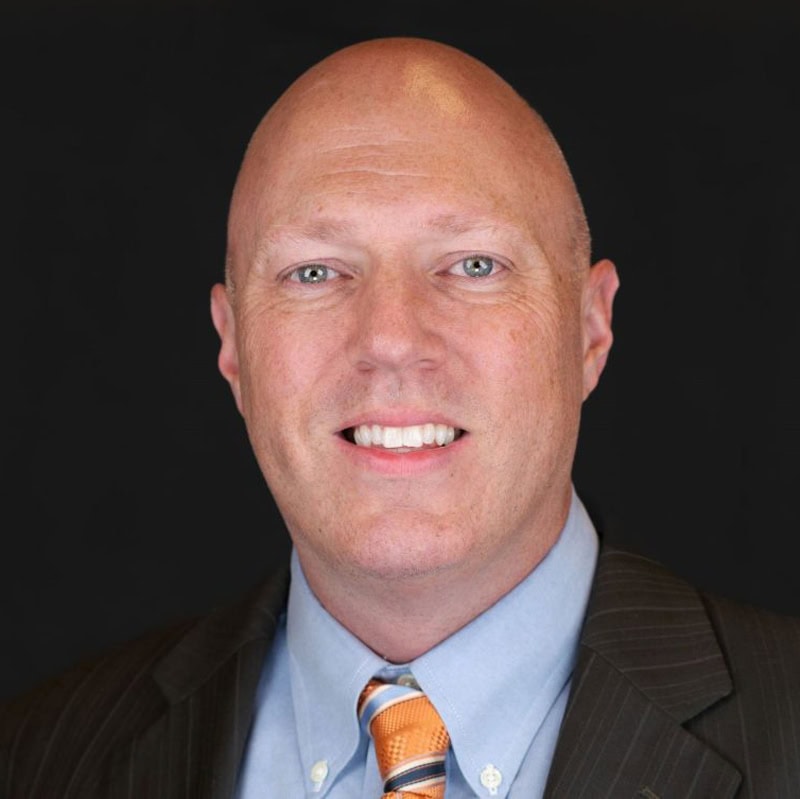 Headshot of Patrick Champman in suit and tie
